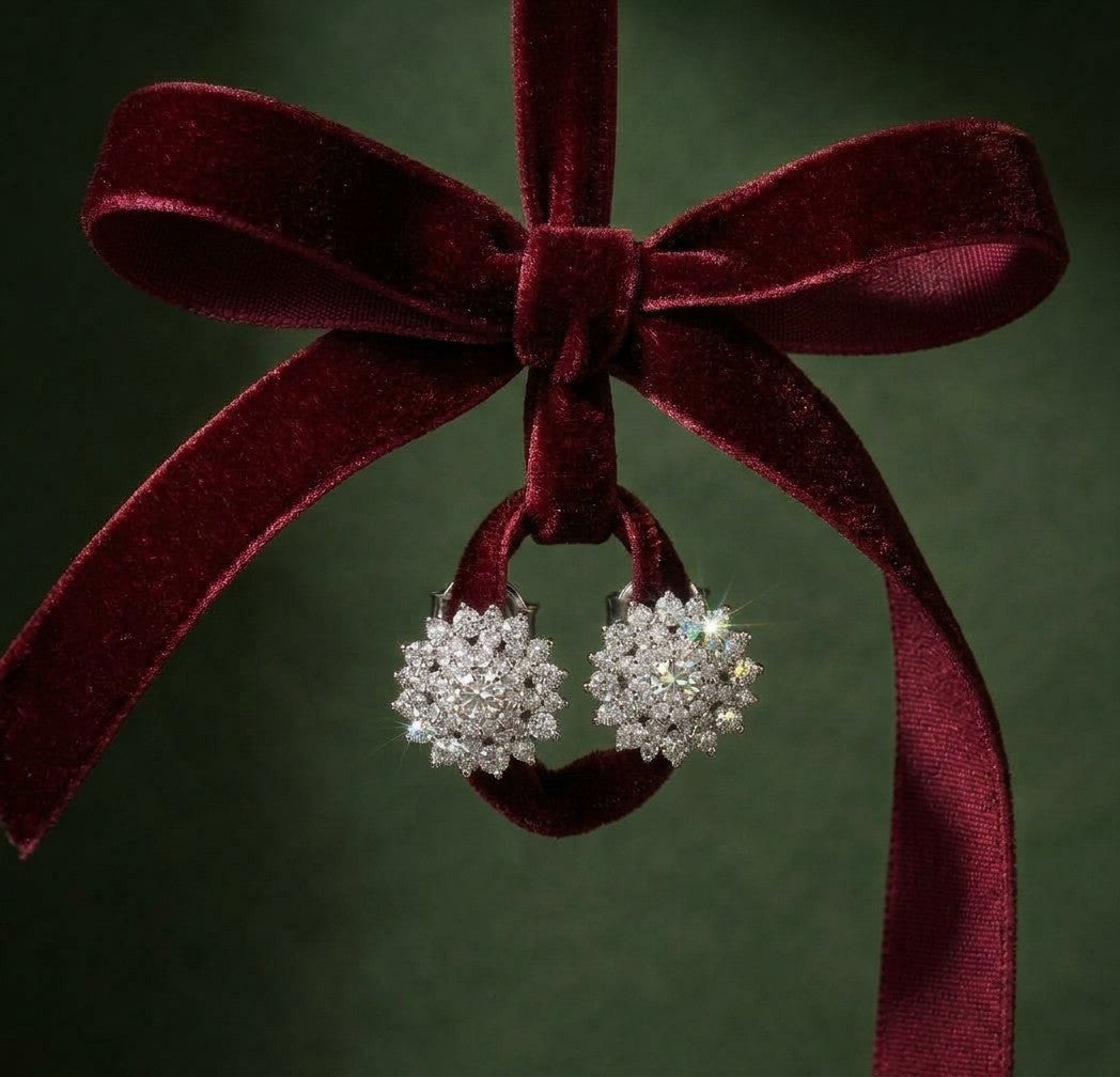Sparkling earrings hanging from a red velvet bow